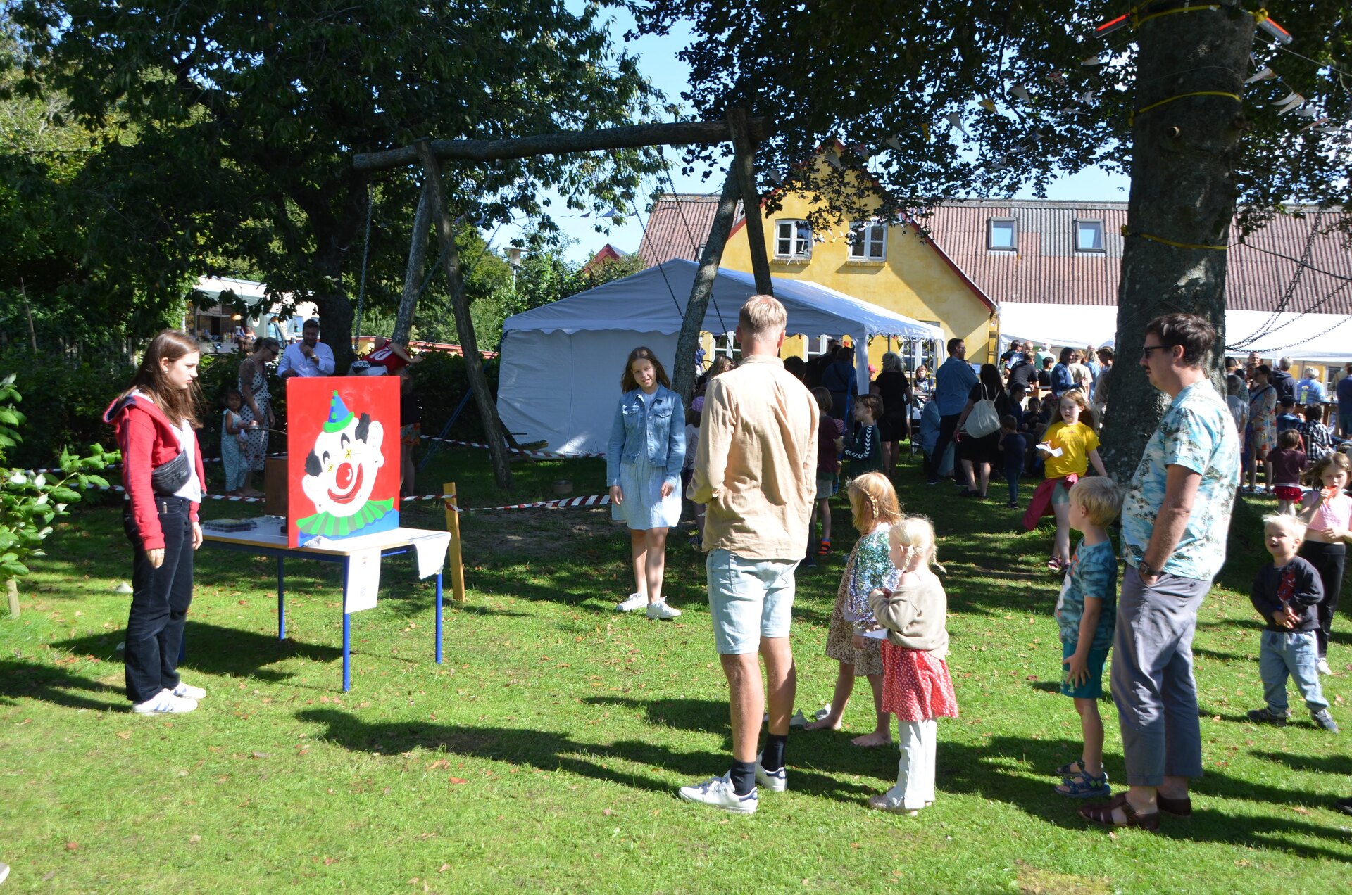 Børn spiller kastespil i haven under festivalen
