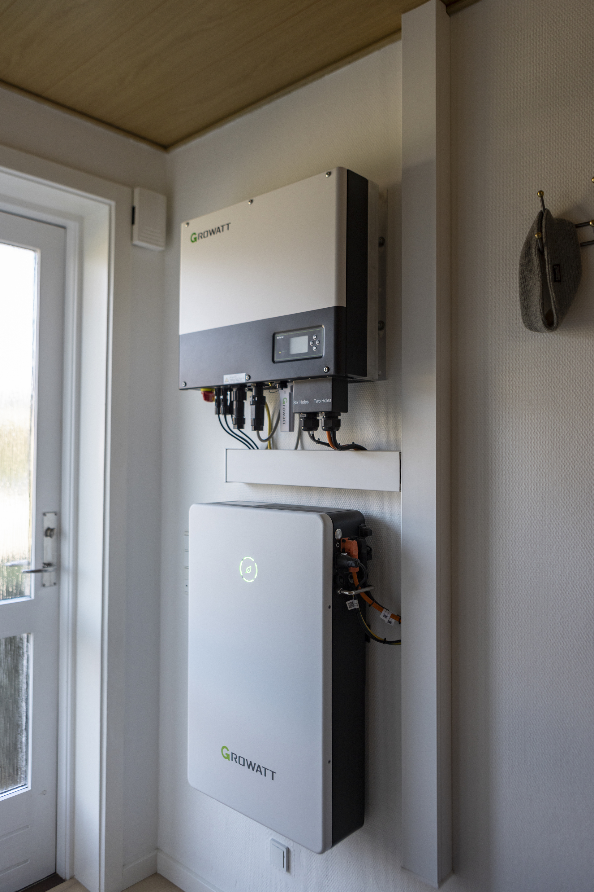 En inverter (øverst) konverterer jævnstrøm til vekselstrøm, som bruges i husstanden. Nederst ses batteriet, som lager strømmen.