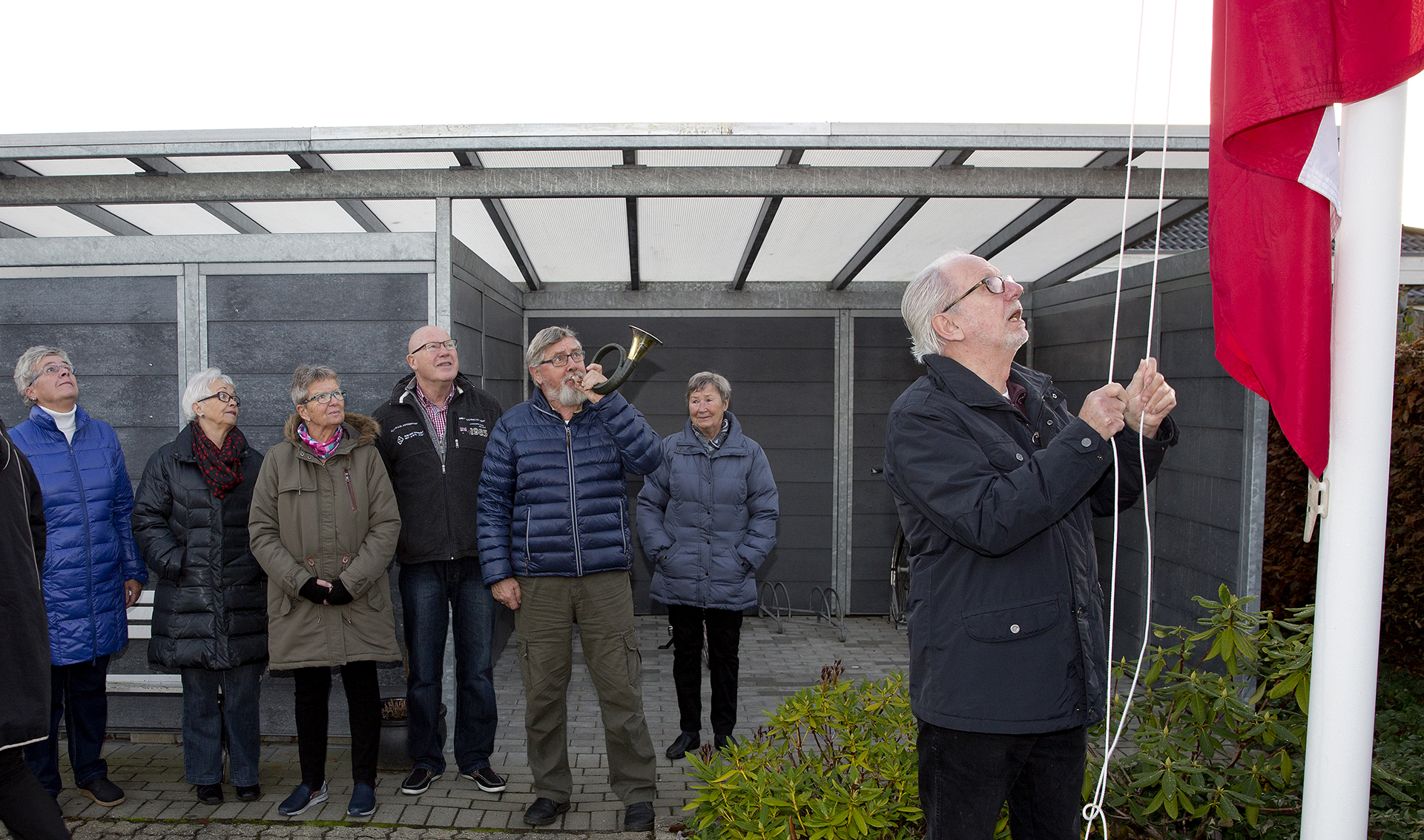 Flaget hejses foran andelshavere, en spiller på jagthorn